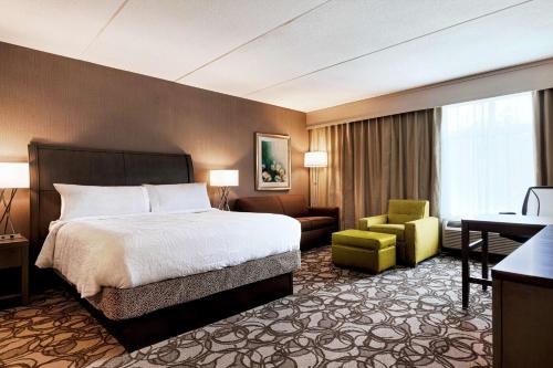 ein Hotelzimmer mit einem Bett und einem Stuhl in der Unterkunft Hilton Garden Inn Lenox Pittsfield in Pittsfield