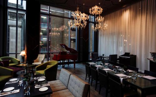 a restaurant with tables and chairs and a piano at Hilton Norfolk The Main in Norfolk