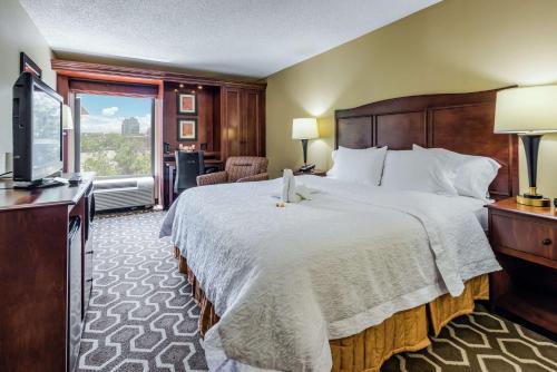 una camera d'albergo con un grande letto e una TV di Hampton Inn Tampa International Airport/Westshore a Tampa