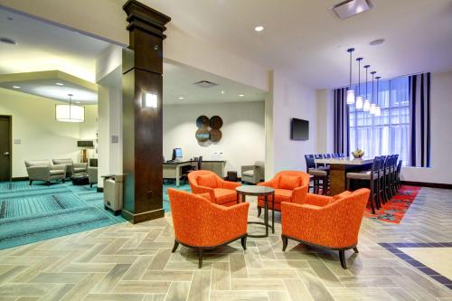 a lobby with orange chairs and a dining room at Hampton Inn & Suites - Roanoke-Downtown, VA in Roanoke