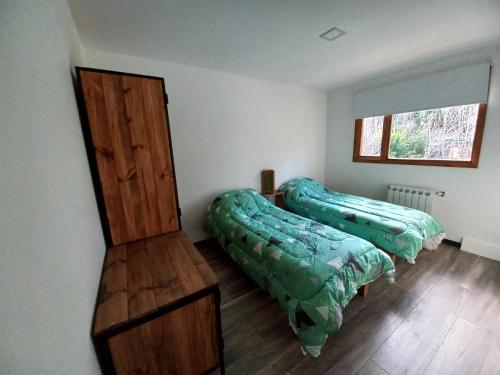 - une chambre avec 2 lits et une armoire en bois dans l'établissement Jen Patagonia, à San Carlos de Bariloche