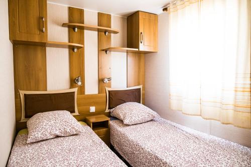 twee bedden naast elkaar in een kamer bij mobil home in Hyères