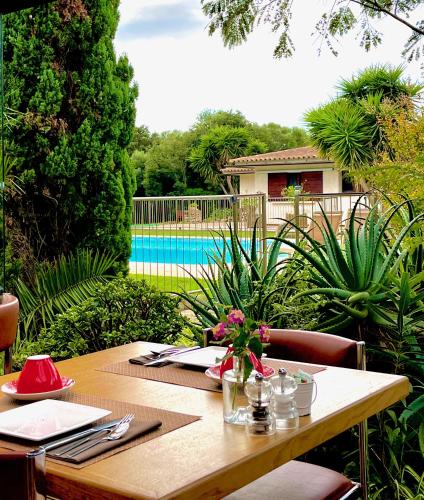 a wooden table in a garden with a table sidx sidx sidx at Poisson Rouge in Bonifacio