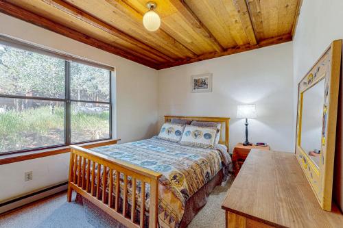um quarto com uma cama e uma grande janela em Timbers Four em Angel Fire