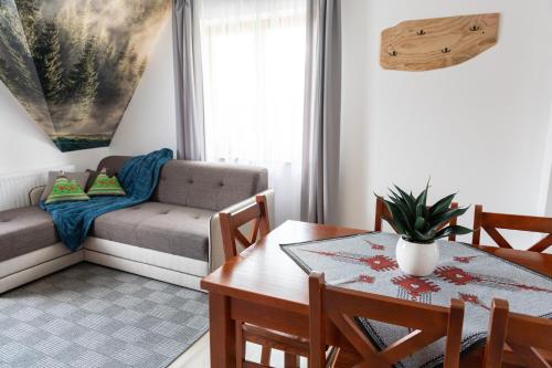 sala de estar con mesa y sofá en Zielony Szlak, en Kościelisko