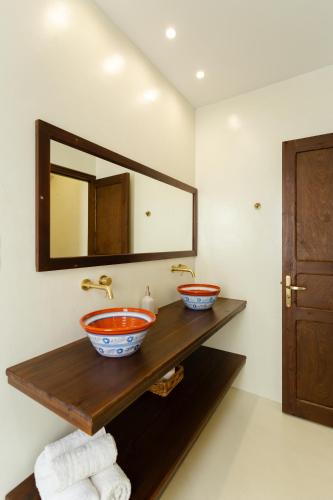 a bathroom with two bowls on a wooden counter with a mirror at Apágkio Filoxenia in Archangelos