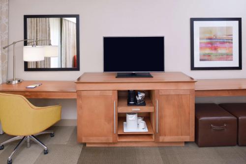 a hotel room with a desk with a television on it at Hampton Inn & Suites by Hilton Lonoke in Lonoke