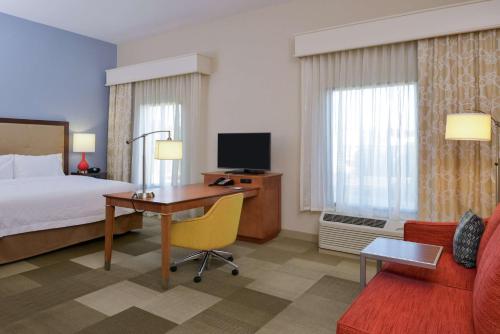 a hotel room with a bed and a desk with a computer at Hampton Inn & Suites by Hilton Lonoke in Lonoke