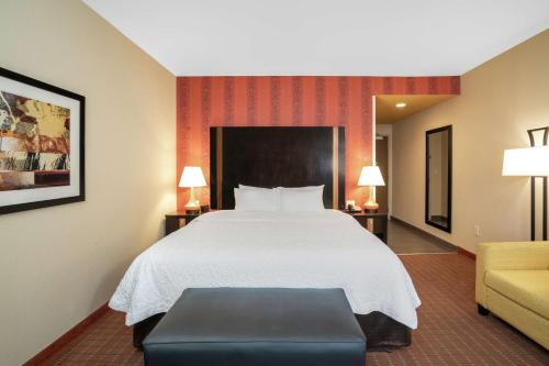 a hotel room with a bed and a couch at Hampton Inn Marion in Marion
