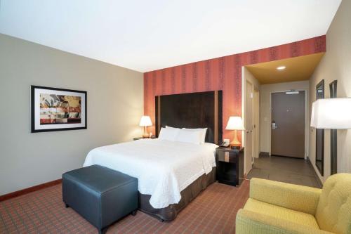 a hotel room with a bed and two chairs at Hampton Inn Marion in Marion