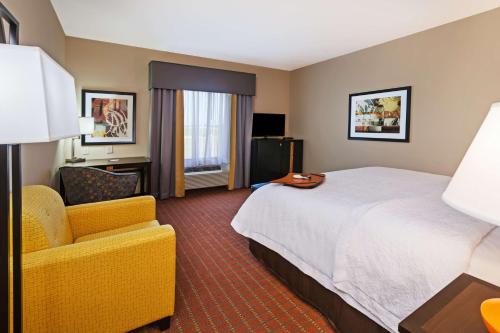 a hotel room with a bed and a chair at Hampton Inn Marion in Marion