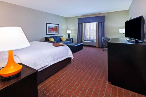 a hotel room with a bed and a flat screen tv at Hampton Inn Marion in Marion