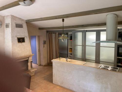 a kitchen with a counter and a fireplace at Villa les Platanes Aix en Provence in Aix-en-Provence