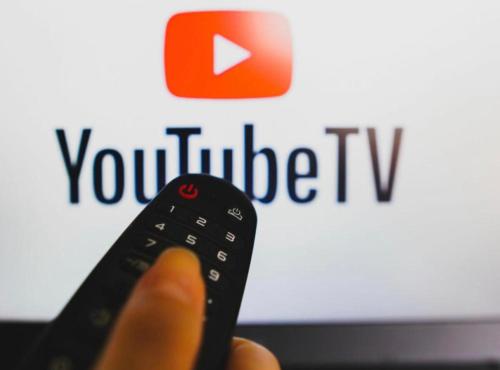 a person holding a remote control in front of a youtube tv at Down-Town 1 Bedroom Flat in Brussels