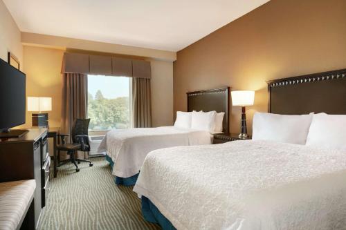 a hotel room with two beds and a television at Hampton Inn and Suites Parkersburg Downtown in Parkersburg