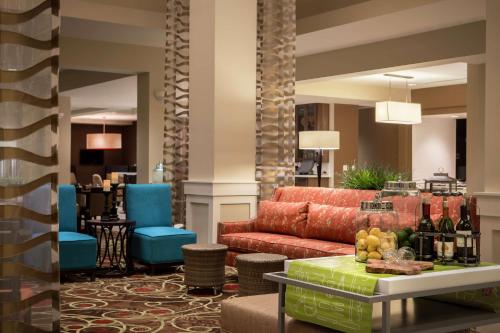 a lobby with a red couch and blue chairs at Hilton Garden Inn Bettendorf/ Quad Cities in Bettendorf