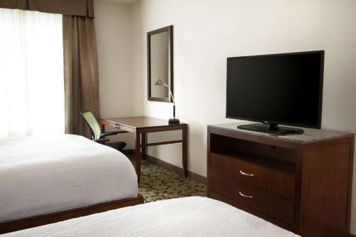 a hotel room with a television and a bed at Hilton Garden Inn Bettendorf/ Quad Cities in Bettendorf