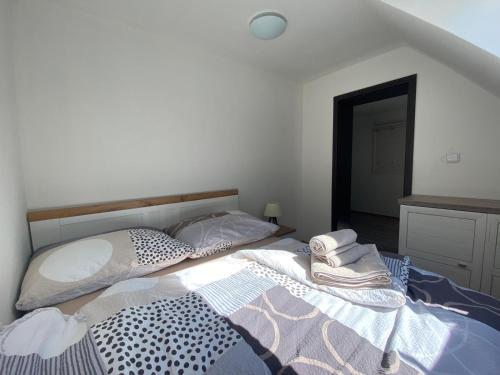 a white bedroom with two beds and a mirror at Penzion U Adama in Karlštejn