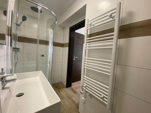 a white bathroom with a sink and a mirror at Penzion U Adama in Karlštejn