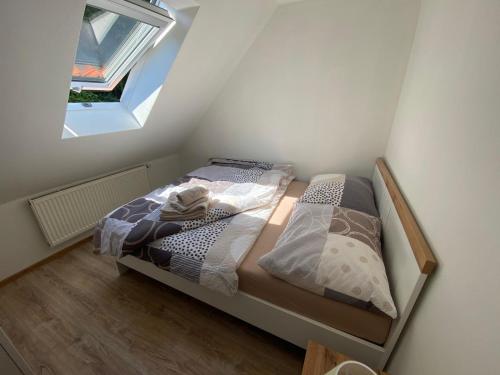 a small bedroom with a bed and a window at Penzion U Adama in Karlštejn