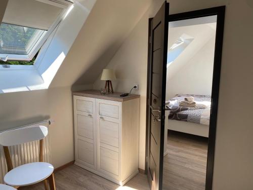 a attic room with a door leading to a bedroom at Penzion U Adama in Karlštejn