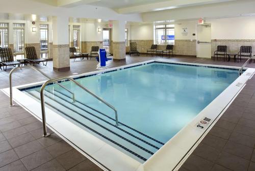 een groot zwembad in een gebouw met tafels en stoelen bij Hilton Garden Inn Roanoke in Roanoke