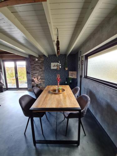 een eetkamer met een tafel en lederen stoelen bij B&B Bos en Wei XL in Hall