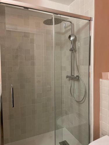 une douche avec une porte vitrée dans une salle de bain dans l'établissement Studio d'architecte à 150 m de la plage, à Royan