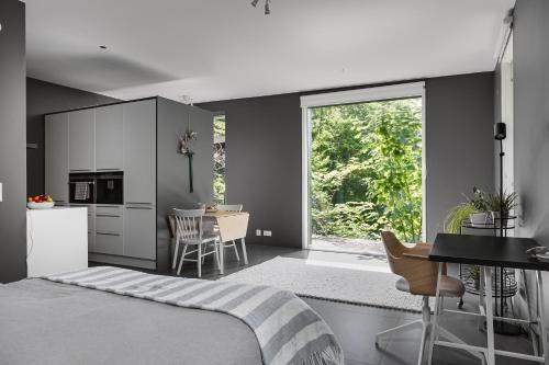 a bedroom with a bed and a kitchen with a table at Style Meets Location in Göteborg in Gothenburg