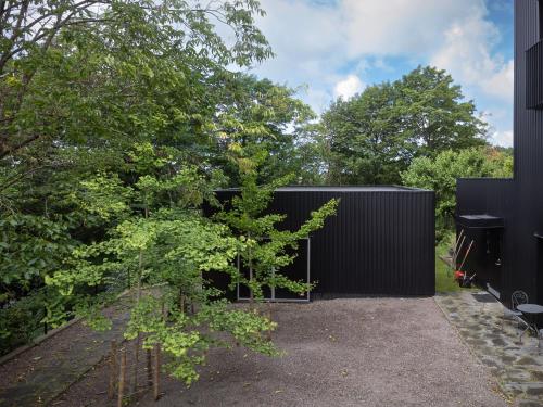 ein schwarzes Gebäude mit Bäumen davor in der Unterkunft Style Meets Location in Göteborg in Göteborg