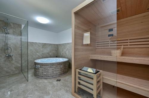 Ruralna kuća za odmor RAJSKI MIR في توهليج: حمام مع حوض استحمام ودش زجاجي
