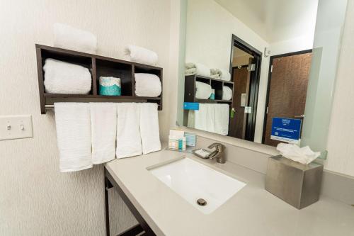 a bathroom with a sink and a mirror and towels at Hampton Inn San Francisco Downtown/Convention Center in San Francisco