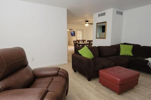 a living room with two leather couches and a stool at Casa Sunrise, Large Home, Minutes from Airport, YRMC, Mexico Borders in Yuma