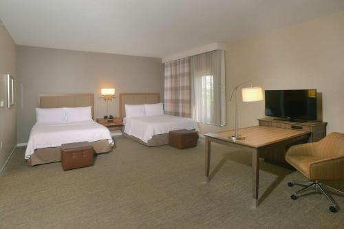 a hotel room with two beds and a flat screen tv at Hampton Inn Springfield-Southeast, MO in Springfield