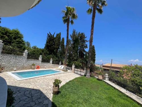 a backyard with a swimming pool and palm trees at Casa StaLa in Kastanéa