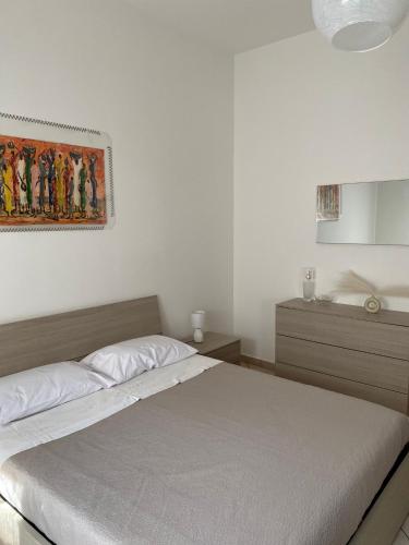 a bedroom with a bed and a painting on the wall at Casangiù in Crispiano