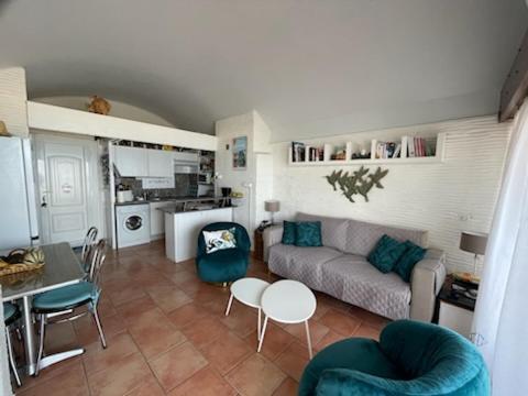 un salon avec un canapé, une table et des chaises dans l'établissement Port cipriano Terrasse face à la mer Wifi Clim Parking, à Saint-Cyprien