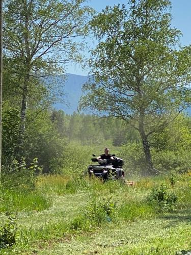 a man riding an atv in a field at River House Moon in Gospić