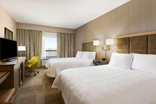 a hotel room with two beds and a flat screen tv at Hampton Inn by Hilton Edmonton/Sherwood Park in Sherwood Park