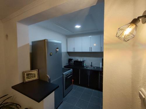 a small kitchen with a refrigerator and a sink at Apartman ASKA in Višegrad