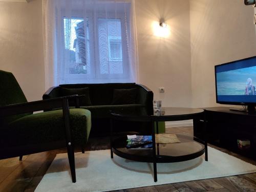 sala de estar con sofá, mesa y TV en Apartman ASKA, en Višegrad