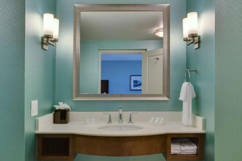 a bathroom with a sink and a mirror at Hilton Garden Inn Daytona Beach Oceanfront in Daytona Beach