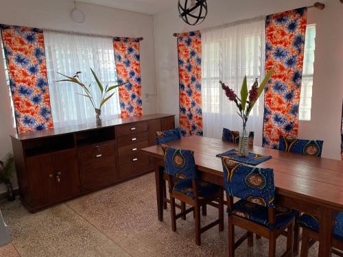 una sala da pranzo con tavolo e sedie in legno di La Villa René a Porto-Novo