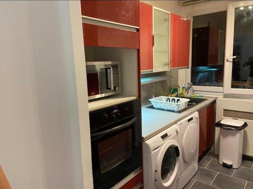 une cuisine avec un lave-linge et un micro-ondes dans l'établissement Appartement T4 Rouen, à Rouen