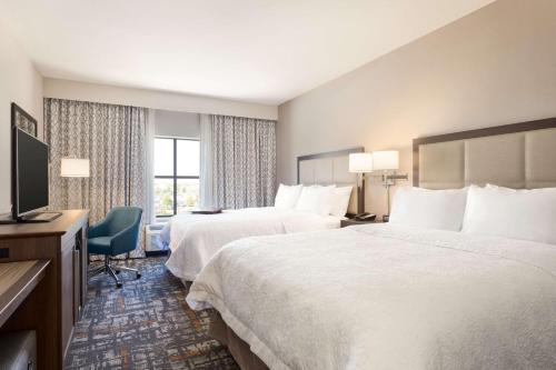 een hotelkamer met 2 bedden en een televisie bij Hampton Inn & Suites West Des Moines Mill Civic in West Des Moines