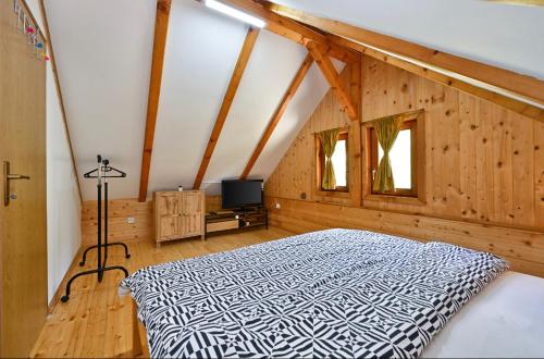 a bedroom with a bed in a room with wooden walls at Ruralna kuća za odmor RAJSKI MIR in Tuhelj