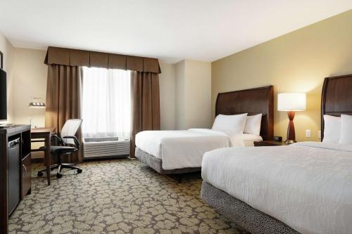 a hotel room with two beds and a desk at Hilton Garden Inn Wallingford/Meriden in Wallingford