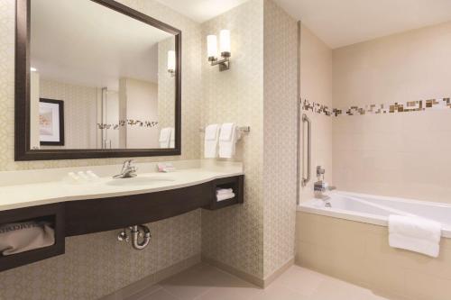 y baño con lavabo, bañera y espejo. en Hilton Garden Inn Wallingford/Meriden, en Wallingford