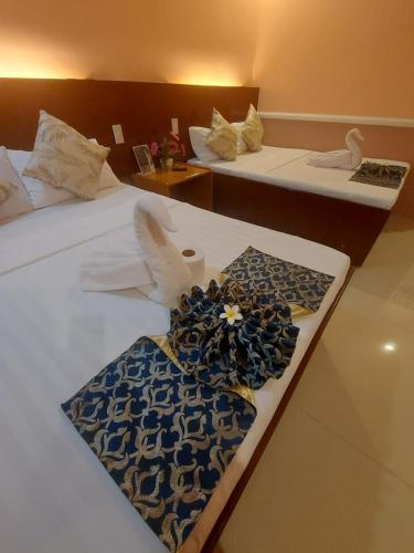 a hotel room with two beds with flowers on them at New Village Lodge in Oslob