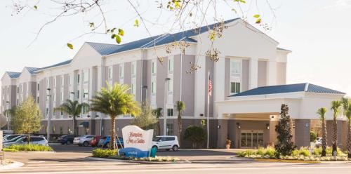 - un grand bâtiment blanc avec un panneau devant dans l'établissement Hampton Inn & Suites Orlando near SeaWorld, à Orlando